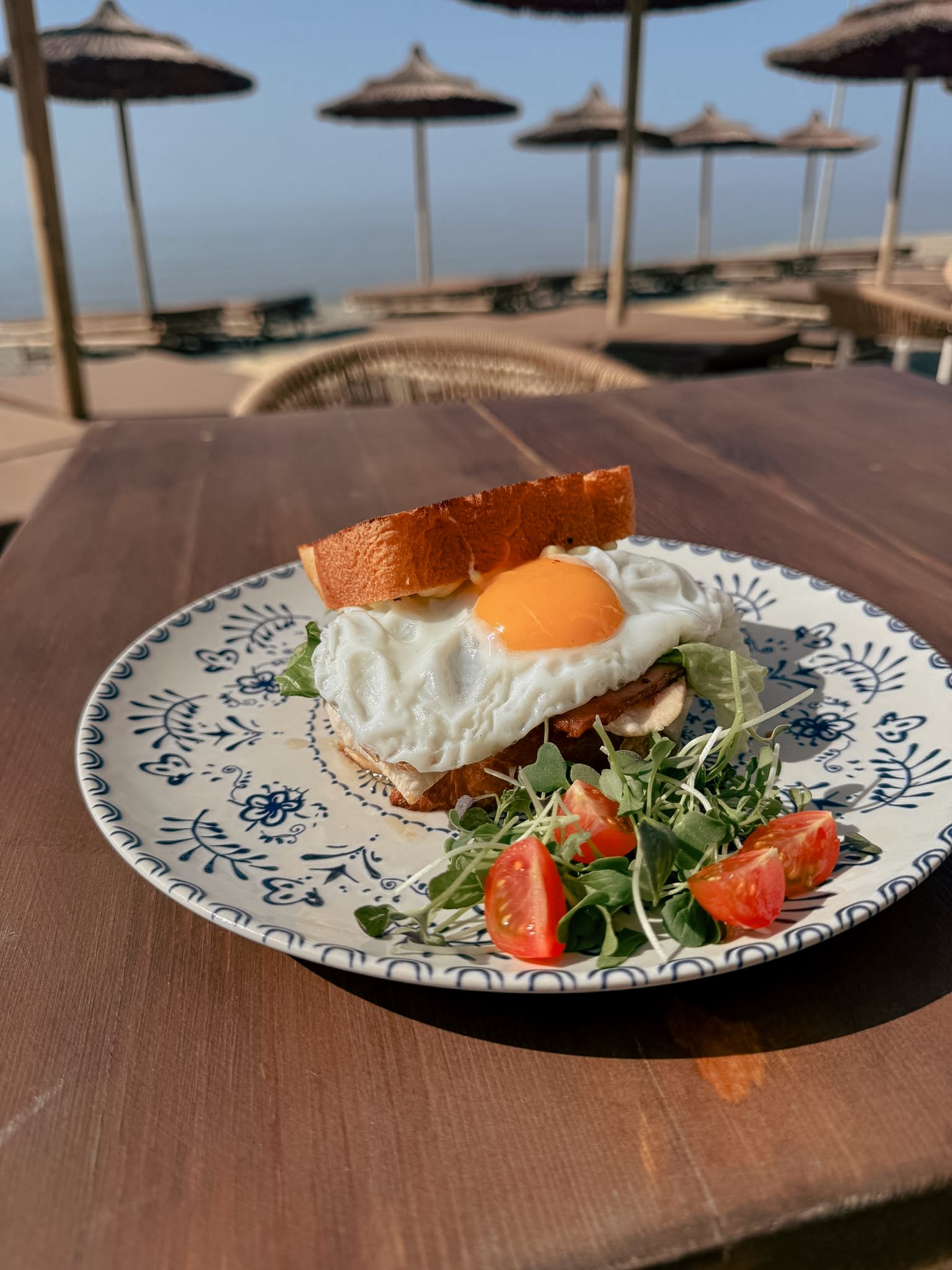 Eggs Benedict del brunch de Solo Beach sobre plato de cerámica azul