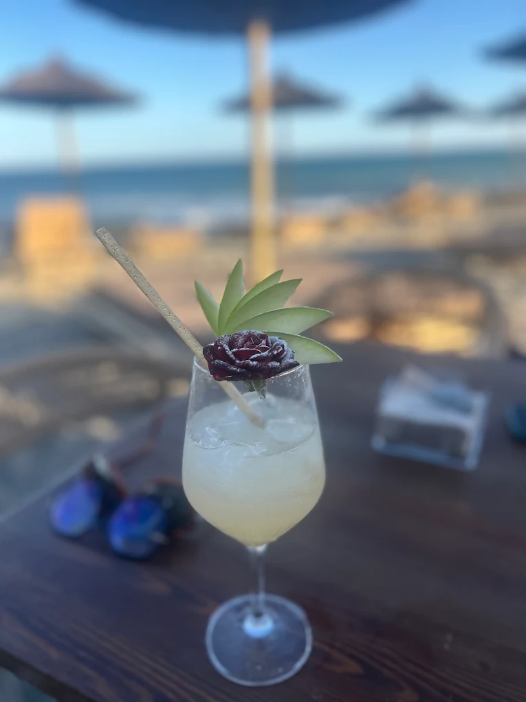 Cóctel de autor al atardecer con flor y manzana